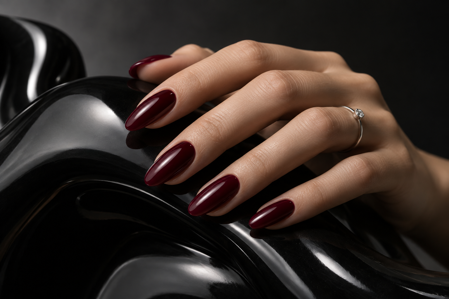 Composição editorial ilustrativa com manicure vinho e anel delicado